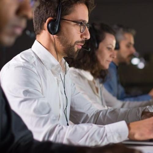 Hombre trabajando con audífonos en un escriptorio